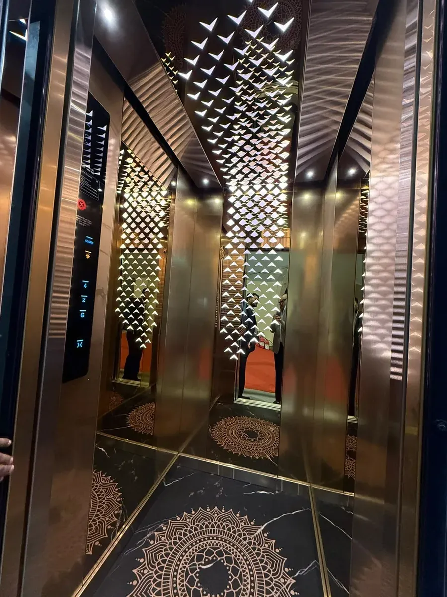 Rose-gold elevator cabin with a laser-cut ceiling and mandala floor inlay