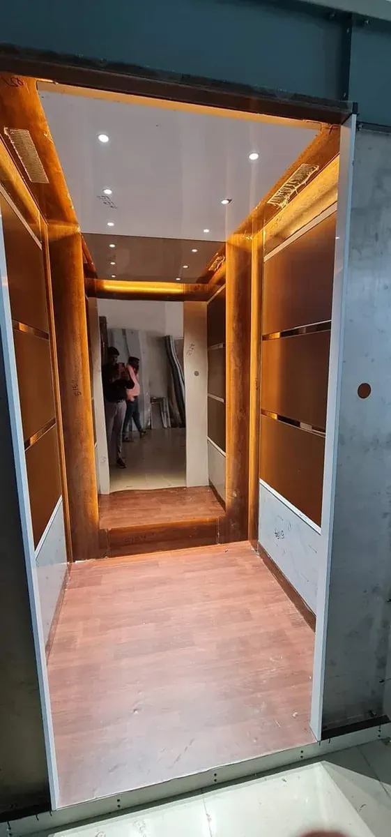 Wood-panel home lift cabin with warm cove lighting